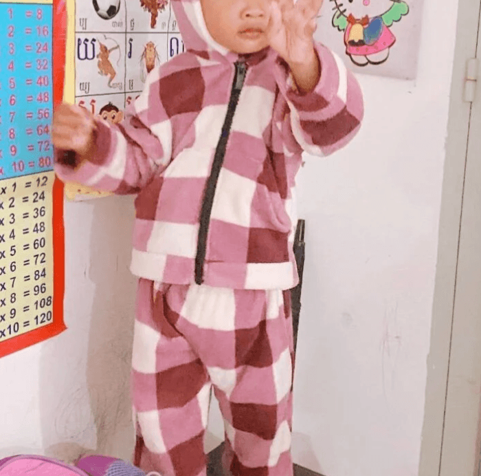 A young child reaching out towards a number chart, showing how to use hand gestures to learn numbers without flashcards.