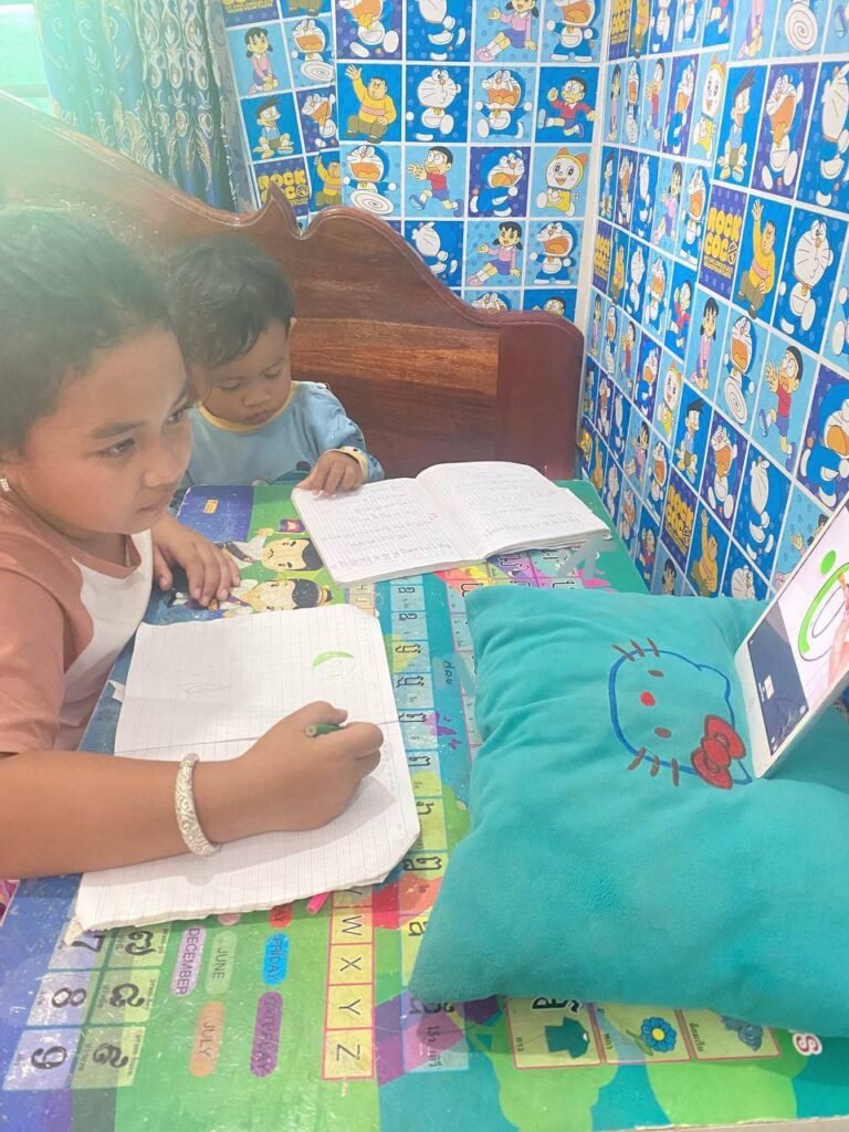 Girl using a letter tracing app on a tablet while her toddler brother watches the screen.