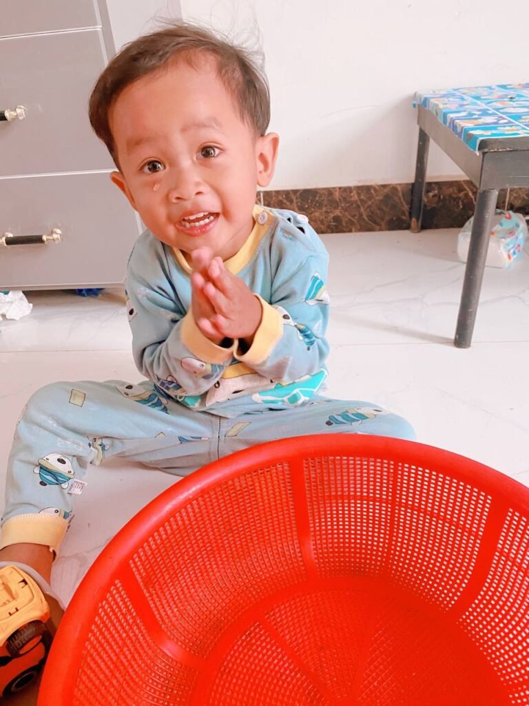 Toddler clasping hands together in a begging gesture asking for help finding a lost toy.