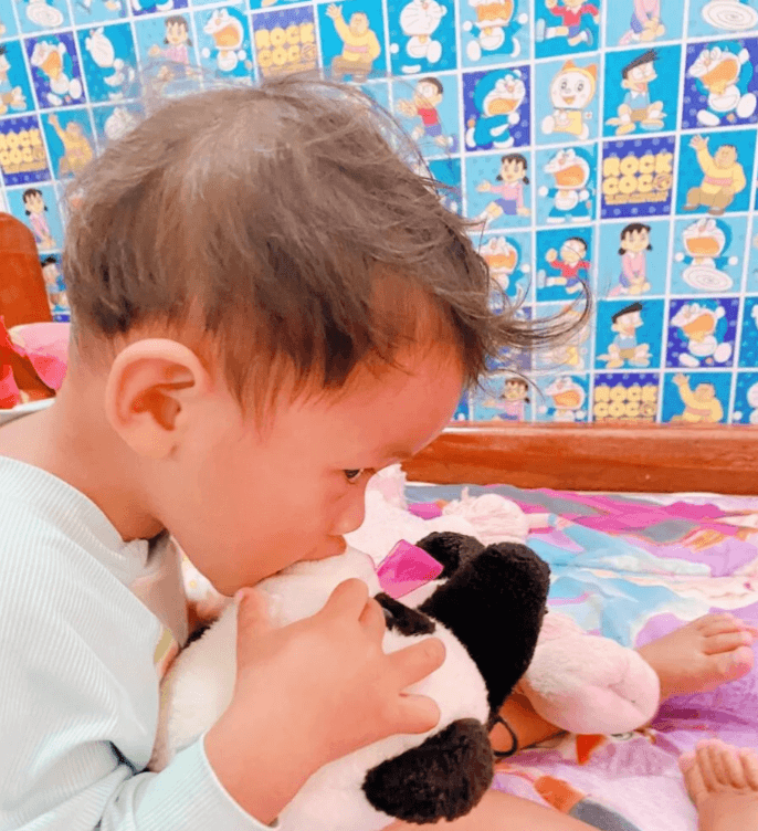 Toddler biting a stuffed panda bear toy as a safe alternative to biting people.