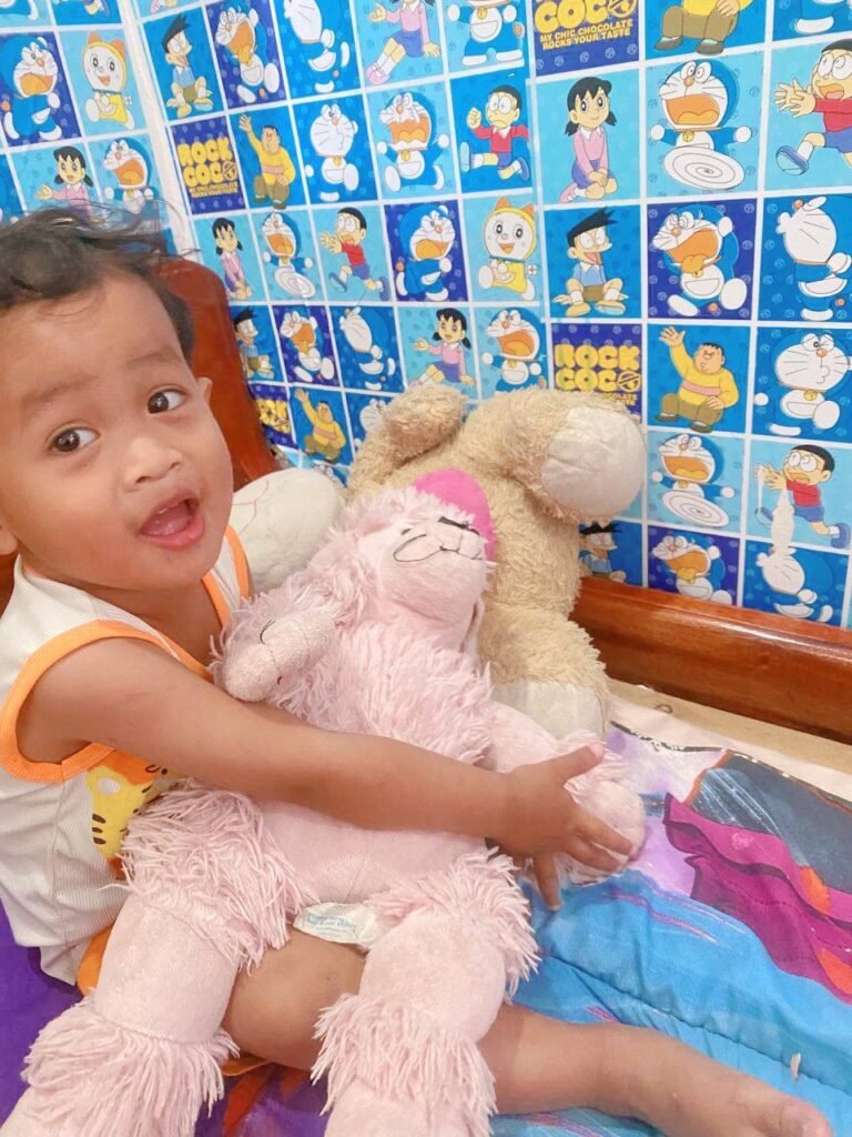 Toddler hugging a pink poodle stuffed animal to practice gentle touches instead of hitting.