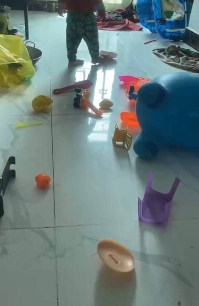 A tile floor completely covered in scattered plastic toys, pots, and baskets.